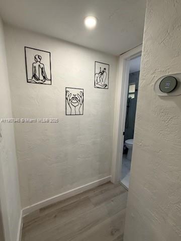 8607 Southwest 68th Court, Unit 27 Pinecrest, FL 33156 - Photo 5 of 9 a view of a hallway with paintings on the wall