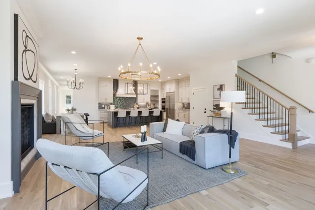 a living room with furniture a fireplace and a chandelier