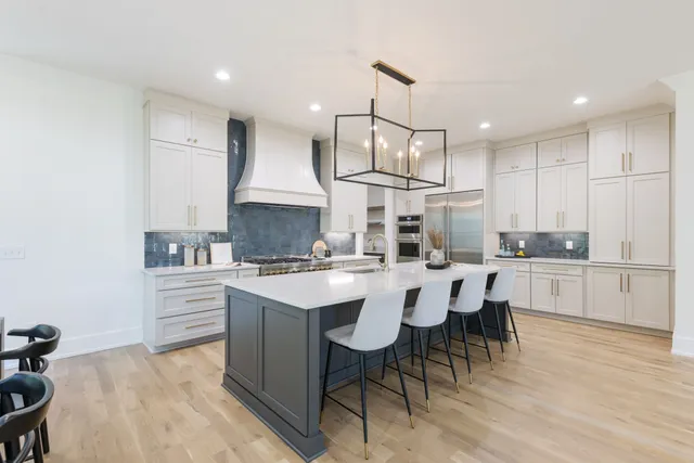 a kitchen with a sink a stove and chairs