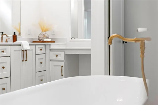 a bathroom with a bathtub sink and mirror