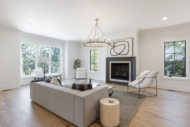 a living room with furniture chandelier and a large window