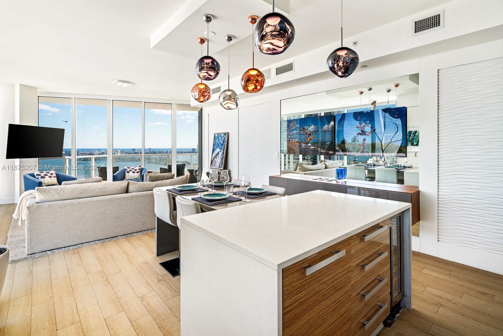 2020 North Bayshore Drive, Unit 4101 Miami, FL 33137 - Photo 6 of 23 a kitchen with a stove a microwave and a table with wooden floor