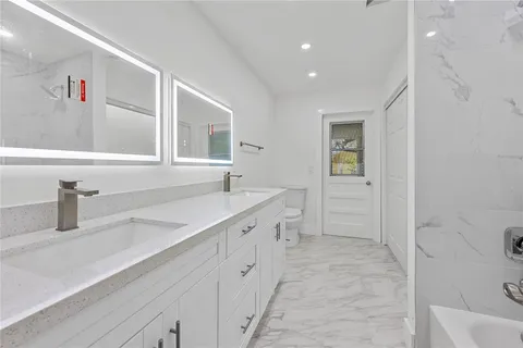 a bathroom with a tub shower and sink