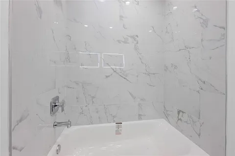 an empty room with a ceiling fan and windows