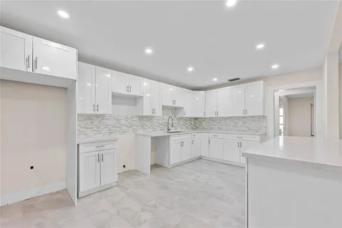 a view of a kitchen with white cabinets