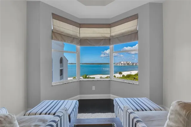 a living room with a bed and a window with balcony view