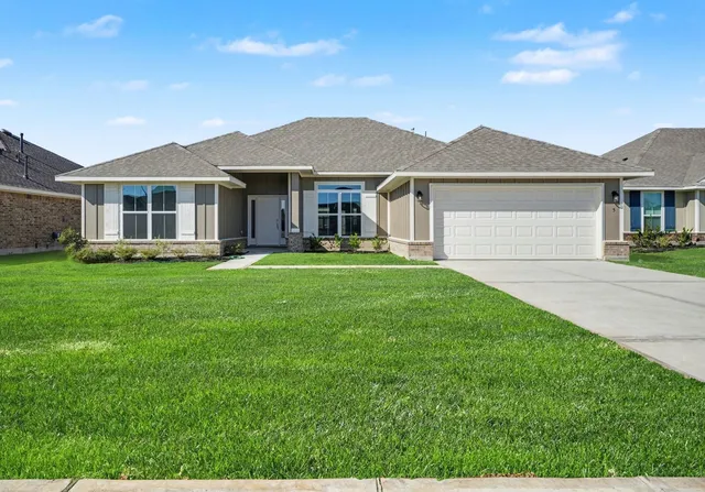 a front view of a house with a garden and trees