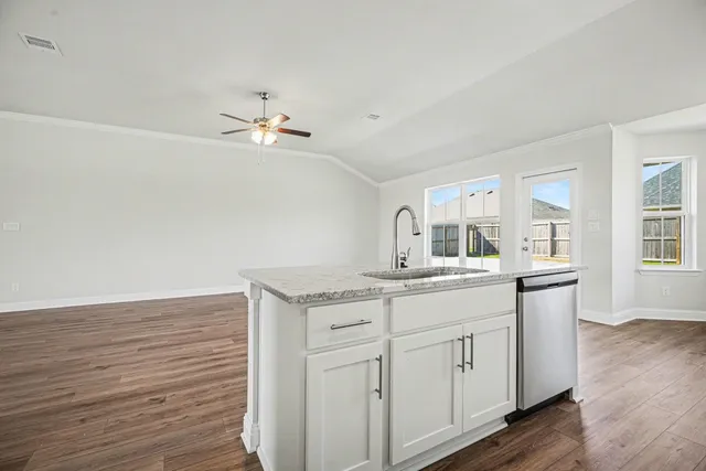 a kitchen with sink cabinets and wooden floor