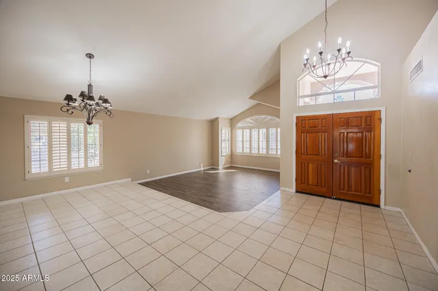 an empty room with windows and chandelier