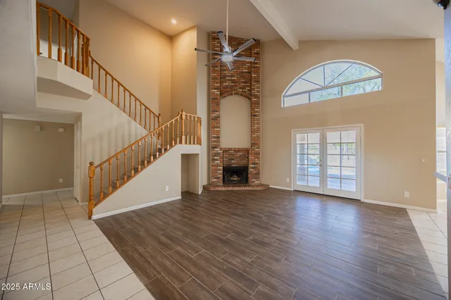 a view of an empty room with a window and fireplace