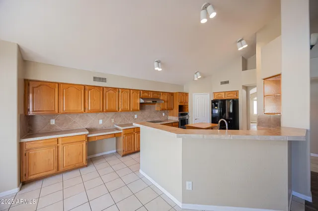 a large kitchen with kitchen island a sink stainless steel appliances and cabinets