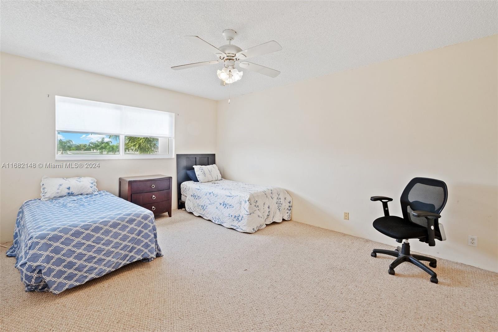 6501 Winfield Boulevard, Unit A31 Margate, FL 33063 - Photo 17 of 25 a bedroom with two beds and a chandelier