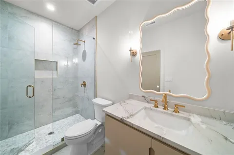 a bathroom with a granite countertop sink toilet and shower