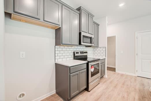 297 Whitetail Circle Canton, GA 30115 - Photo 11 of 35 a kitchen with stainless steel appliances granite countertop a stove a sink and a microwave