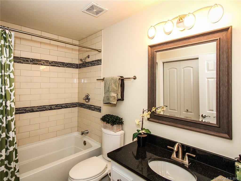 318 Queens Road, Unit 5 Charlotte, NC 28204 - Photo 17 of 24 a bathroom with a granite countertop sink mirror toilet and bathtub