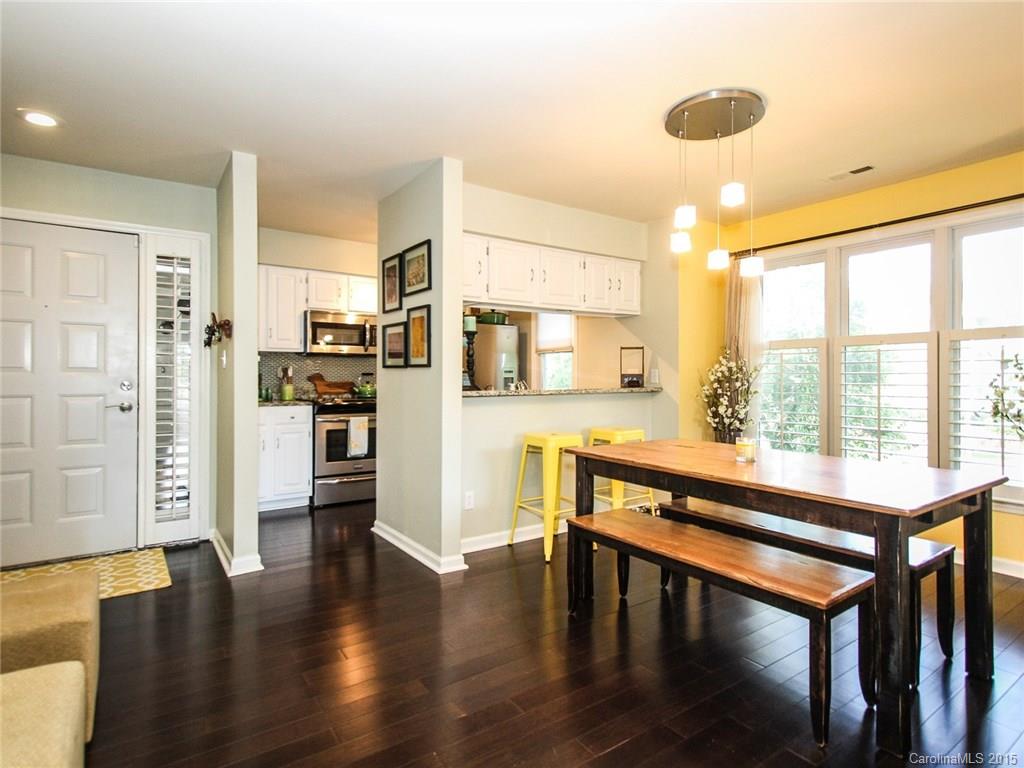 318 Queens Road, Unit 5 Charlotte, NC 28204 - Photo 7 of 24 a large living room with stainless steel appliances kitchen island granite countertop a large window and wooden floor