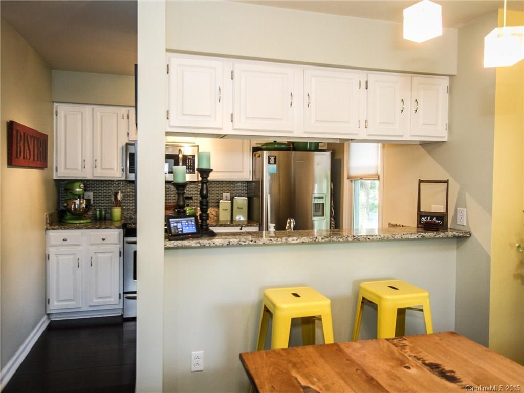 318 Queens Road, Unit 5 Charlotte, NC 28204 - Photo 8 of 24 a kitchen with stainless steel appliances white cabinets and wooden floor