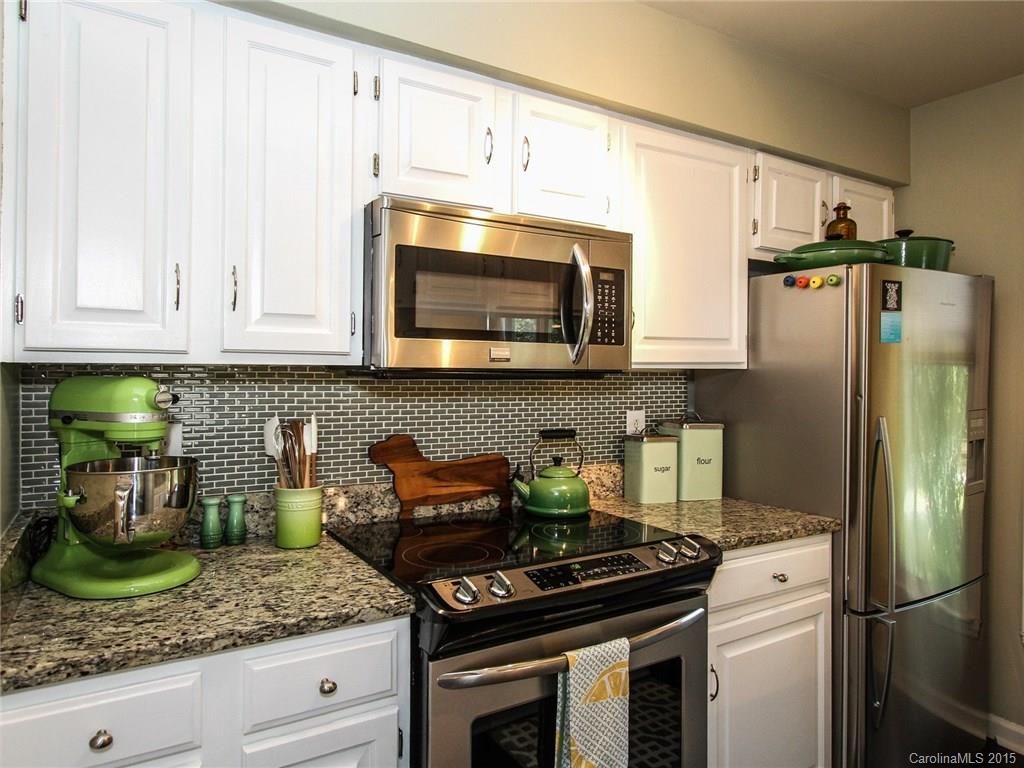 318 Queens Road, Unit 5 Charlotte, NC 28204 - Photo 9 of 24 a kitchen with granite countertop stainless steel appliances and white cabinets