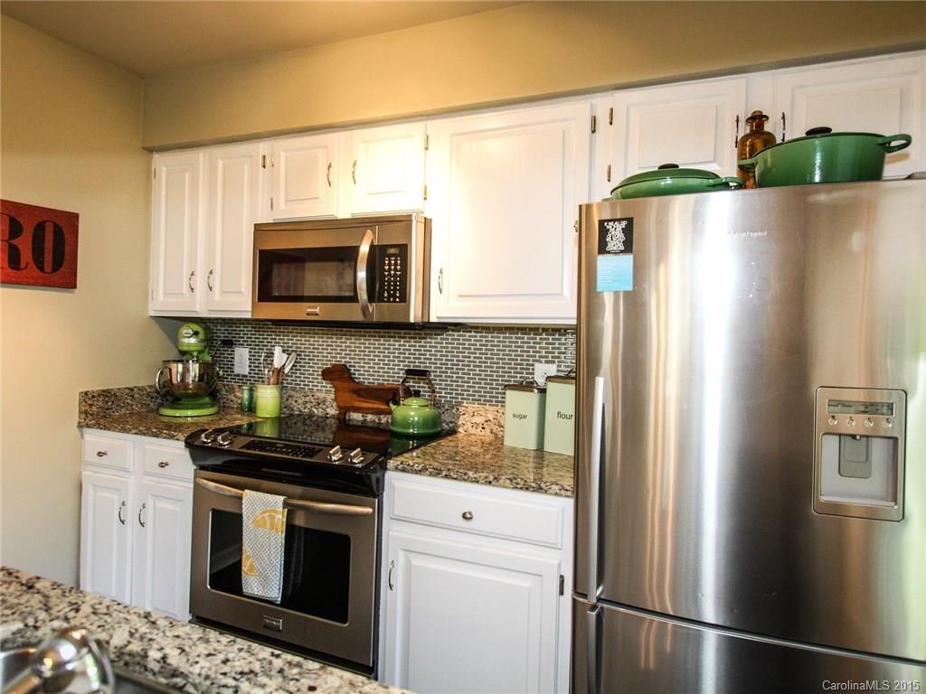 318 Queens Road, Unit 5 Charlotte, NC 28204 - Photo 10 of 24 a kitchen with stainless steel appliances granite countertop a refrigerator a stove a sink and a microwave