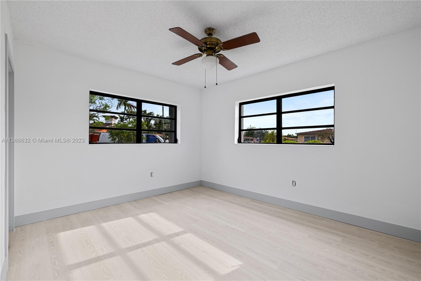 Westhaven Park Hialeah, FL 33012 - Photo 13 of 22 an empty room with windows and ceiling fan