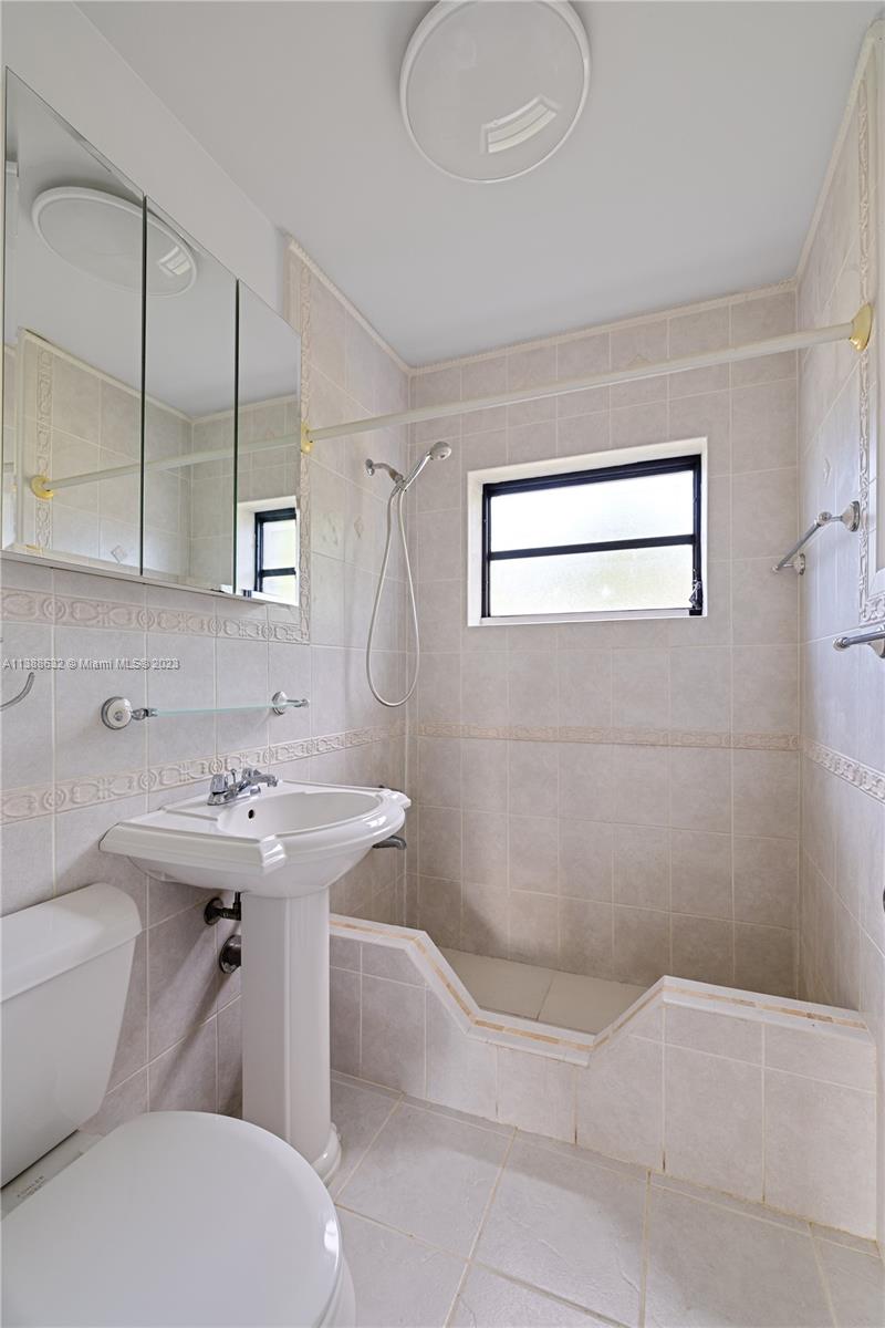 Westhaven Park Hialeah, FL 33012 - Photo 16 of 22 a bathroom with a sink a toilet and mirror