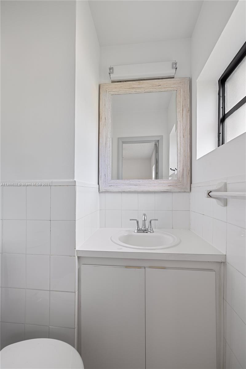 Westhaven Park Hialeah, FL 33012 - Photo 19 of 22 a bathroom with a toilet sink and mirror
