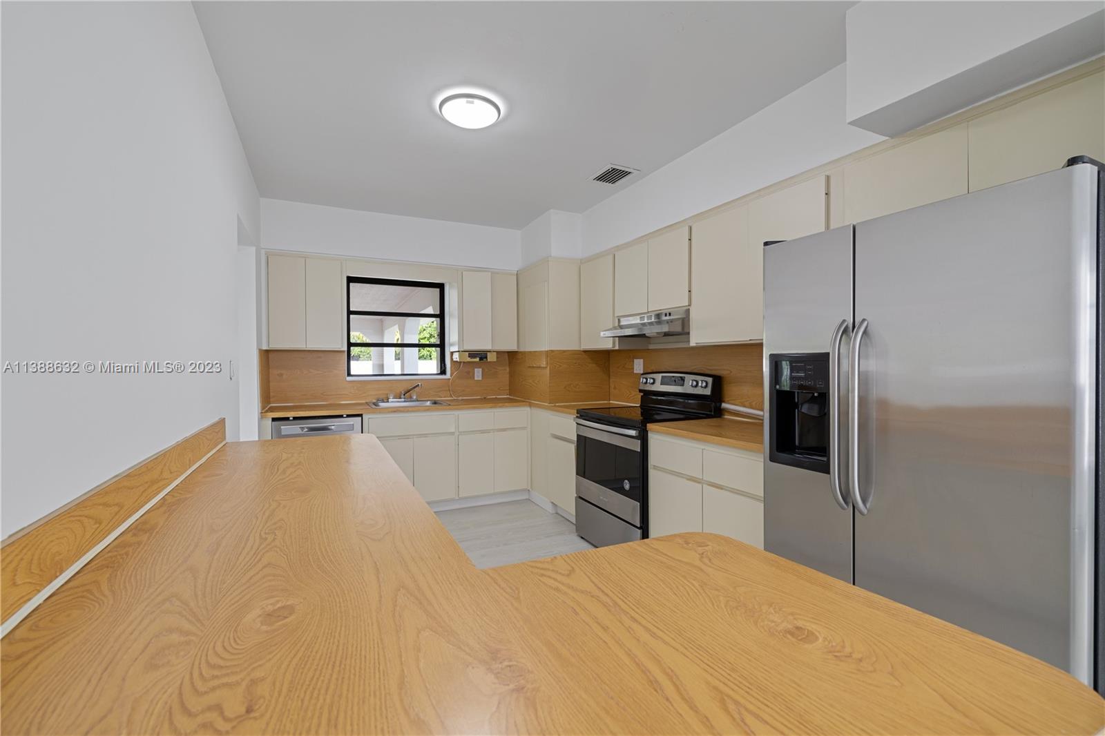 Westhaven Park Hialeah, FL 33012 - Photo 20 of 22 a kitchen with granite countertop a refrigerator and a stove top oven