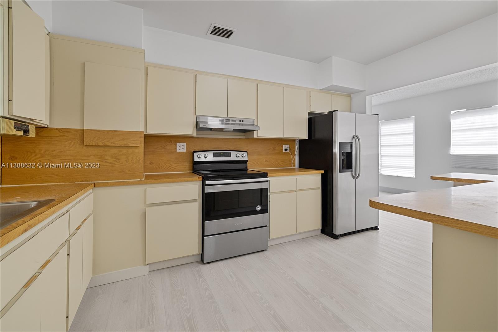 Westhaven Park Hialeah, FL 33012 - Photo 21 of 22 a kitchen with granite countertop white cabinets and white appliances