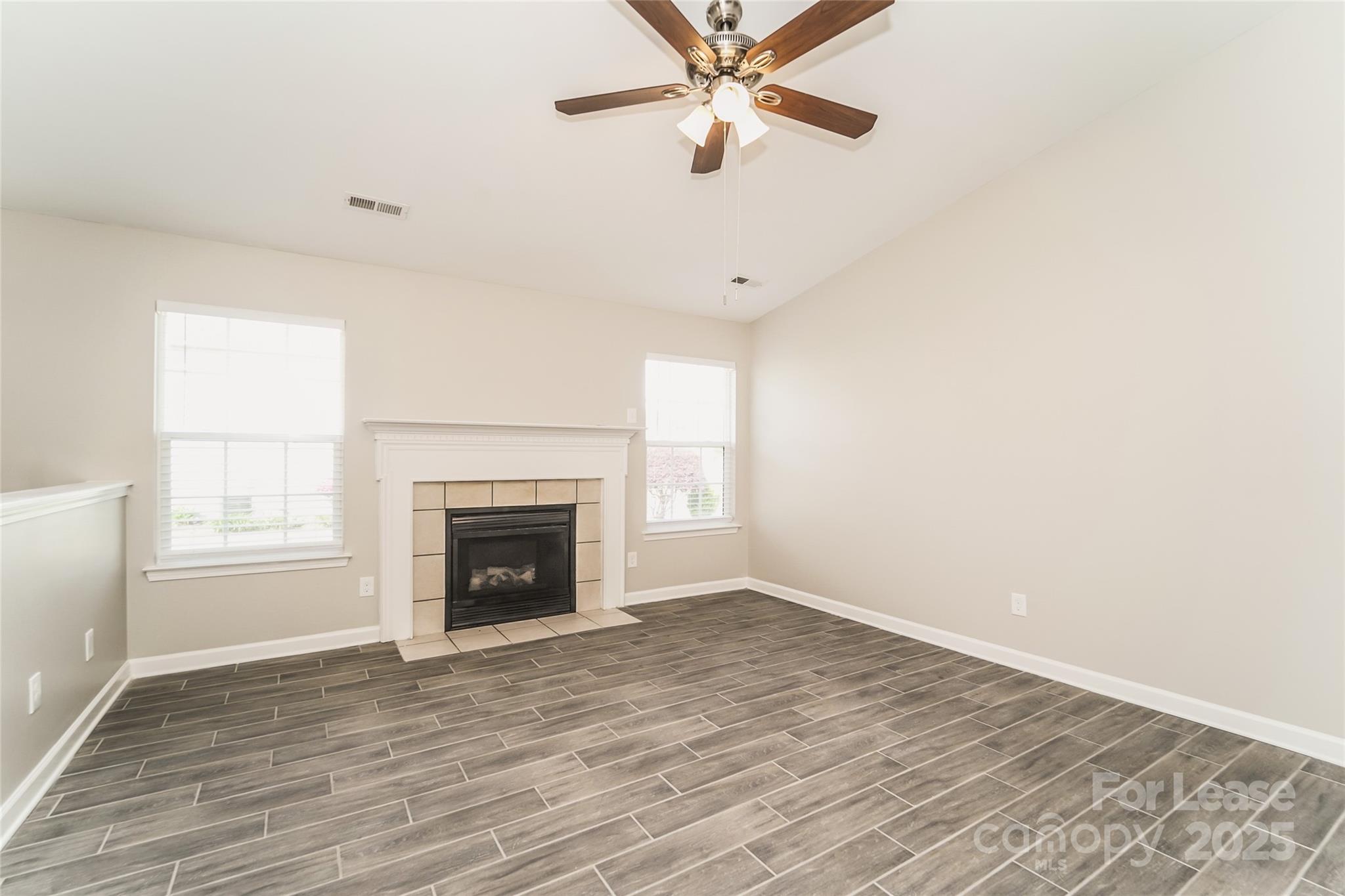 3931 Bitterroot Court Charlotte, NC 28269 - Photo 5 of 16 a view of an empty room with wooden floor fireplace and a window