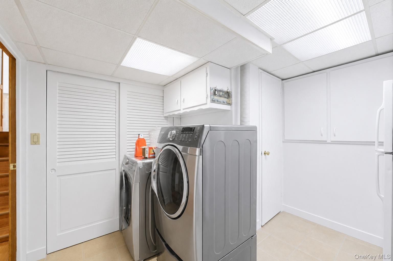 29 Montrose Road Yonkers, NY 10710 - Photo 20 of 39 Dedicated laundry area featuring white cabinetry, light-toned flooring, and contemporary overhead lighting