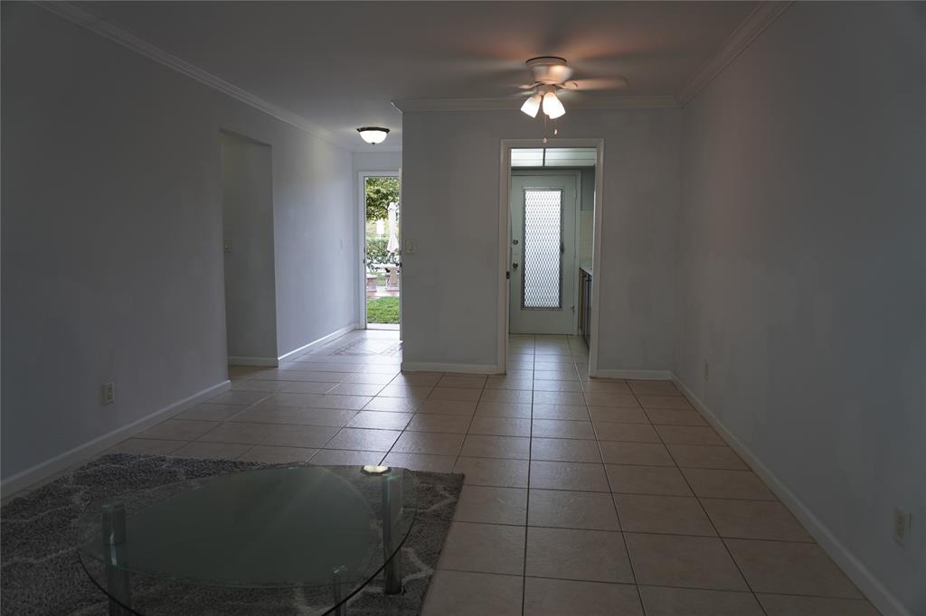1050 East Sample Road, Unit 104 Pompano Beach, FL 33064 - Photo 12 of 14 a view of a hallway with wooden floor and a chandelier