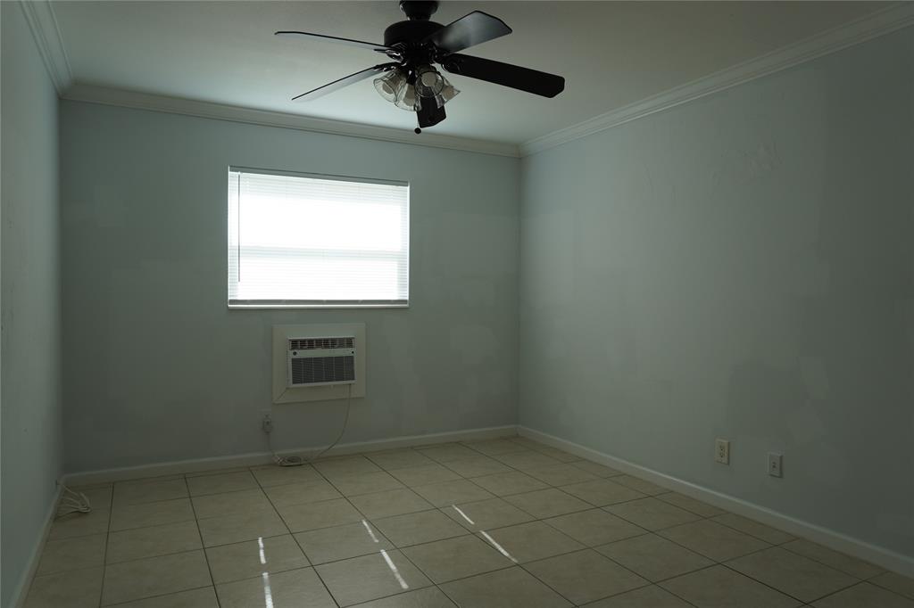1050 East Sample Road, Unit 104 Pompano Beach, FL 33064 - Photo 13 of 14 an empty room with a window and a fan