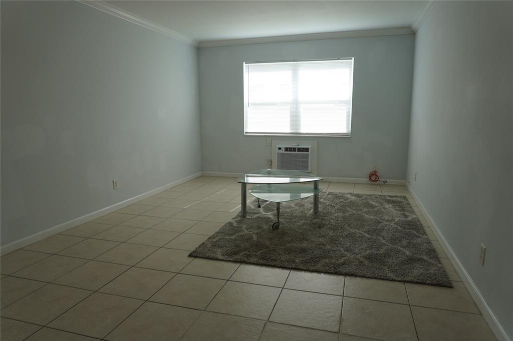1050 East Sample Road, Unit 104 Pompano Beach, FL 33064 - Photo 4 of 14 a bathroom with a toilet a sink a mirror and a window
