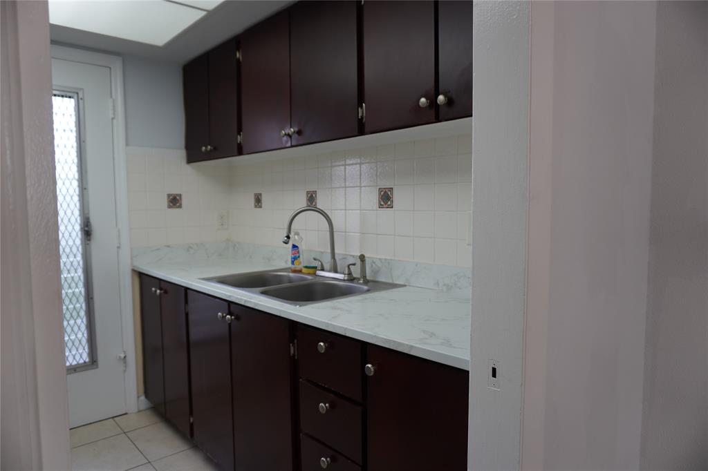 1050 East Sample Road, Unit 104 Pompano Beach, FL 33064 - Photo 6 of 14 a kitchen with a sink and cabinets