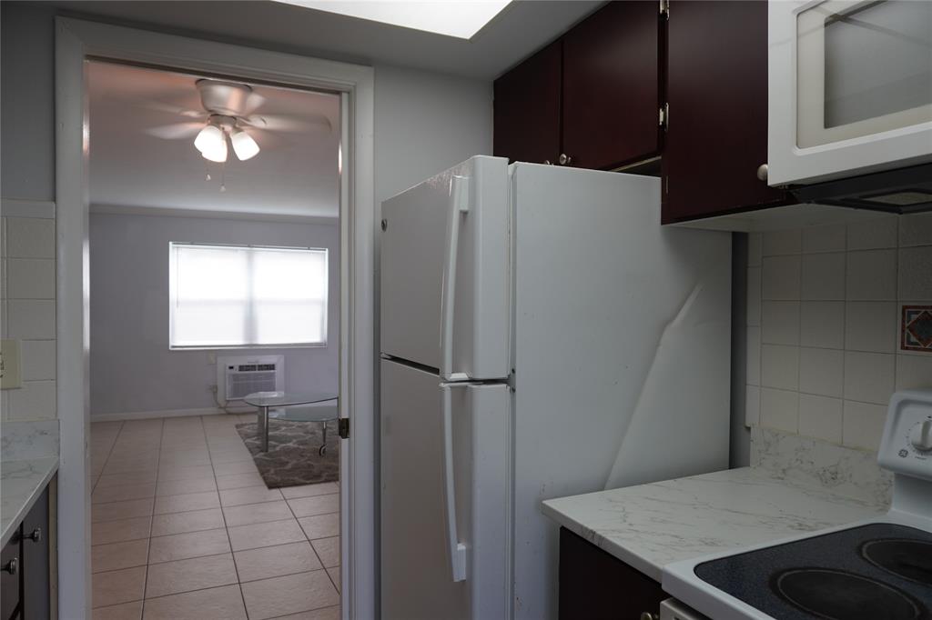 1050 East Sample Road, Unit 104 Pompano Beach, FL 33064 - Photo 8 of 14 a kitchen with a refrigerator a sink and dishwasher