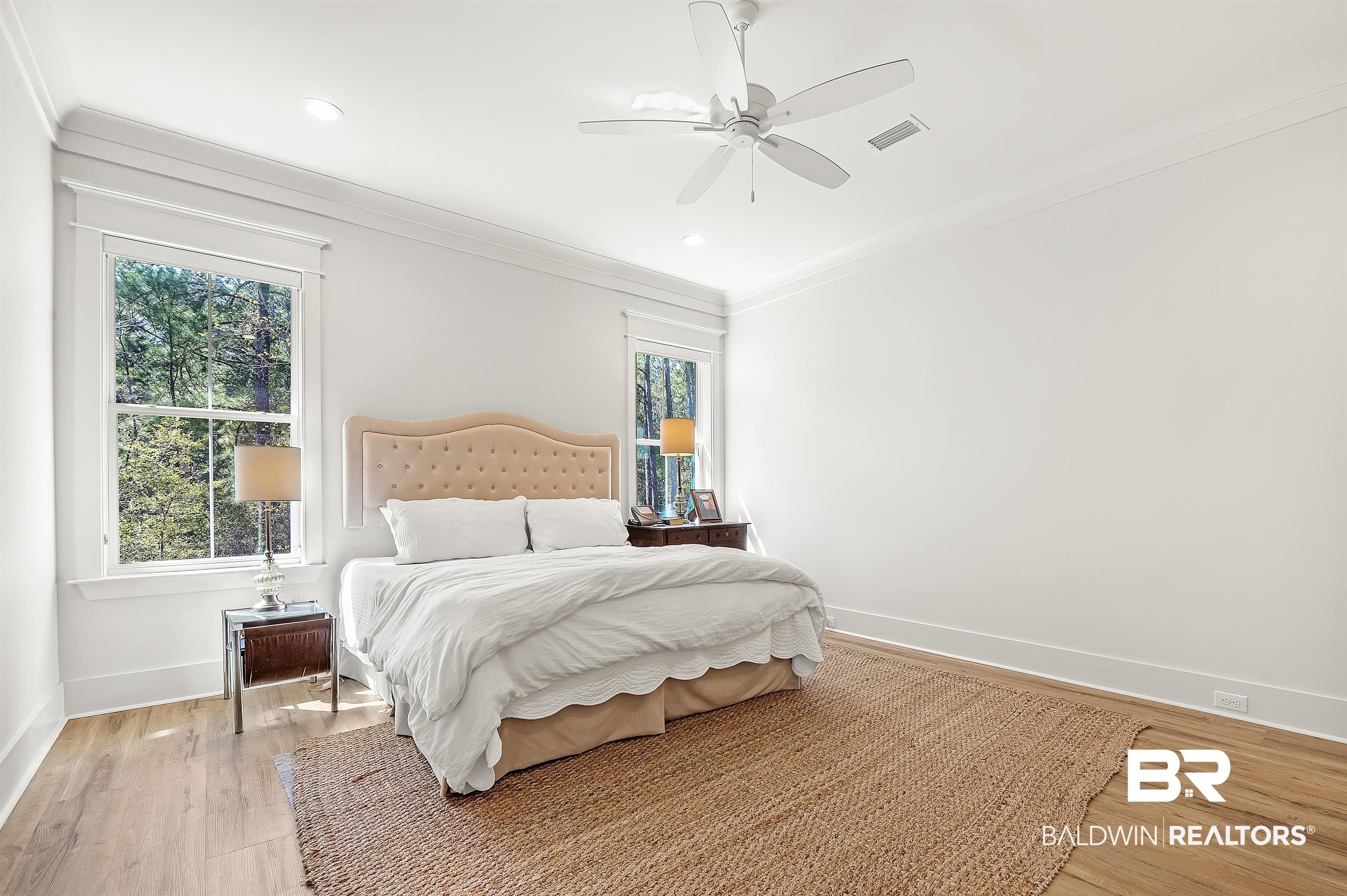 27888 Oakachoy Loop Daphne, AL 36526 - Photo 22 of 65 Bedroom with crown molding, baseboards, light wood-style floors, visible vents, and a ceiling fan