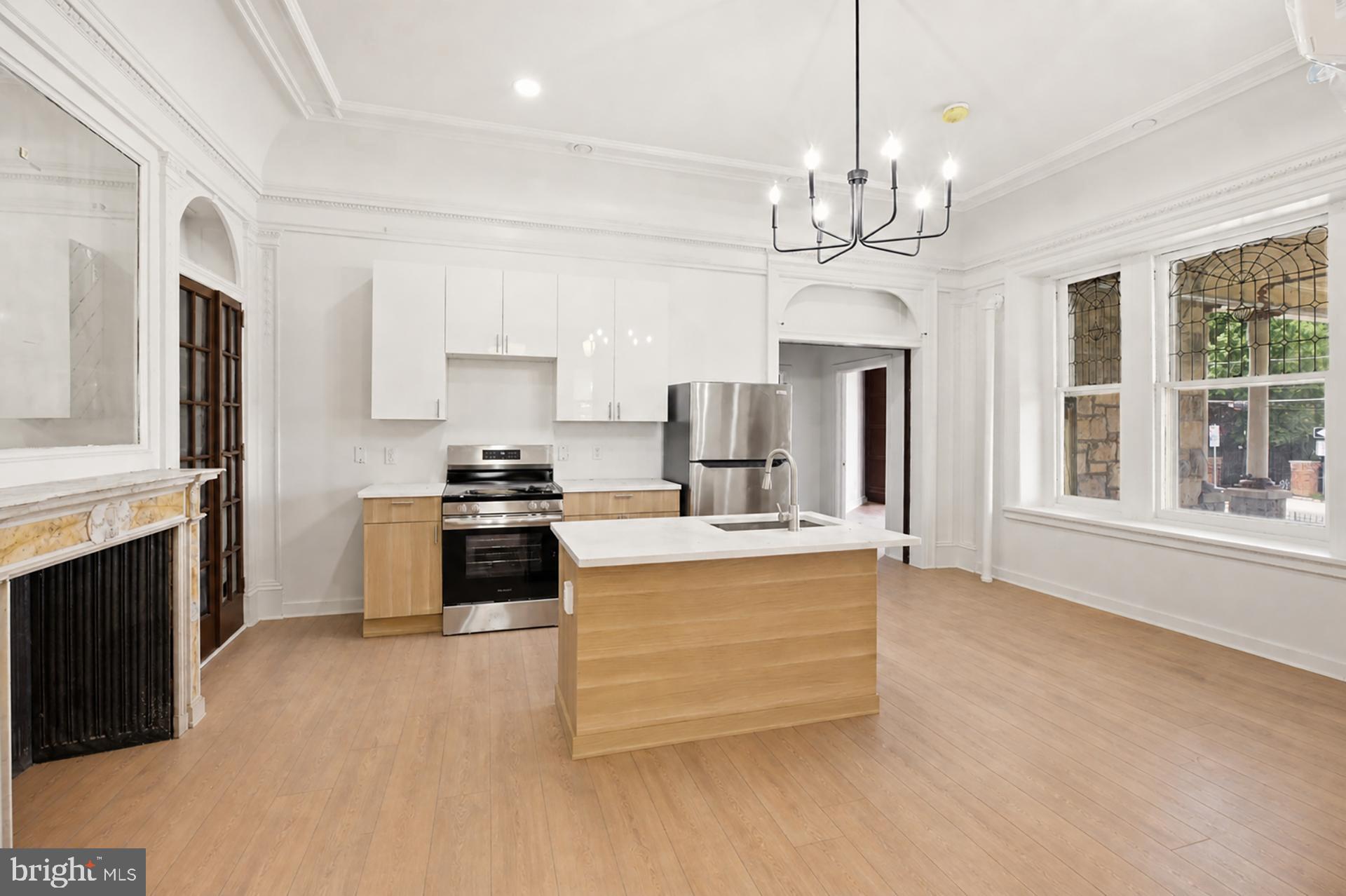 6012 Ridge Avenue, Unit 1 Philadelphia, PA 19128 - Photo 2 of 17 a large kitchen with granite countertop a stove a sink a refrigerator and a fireplace