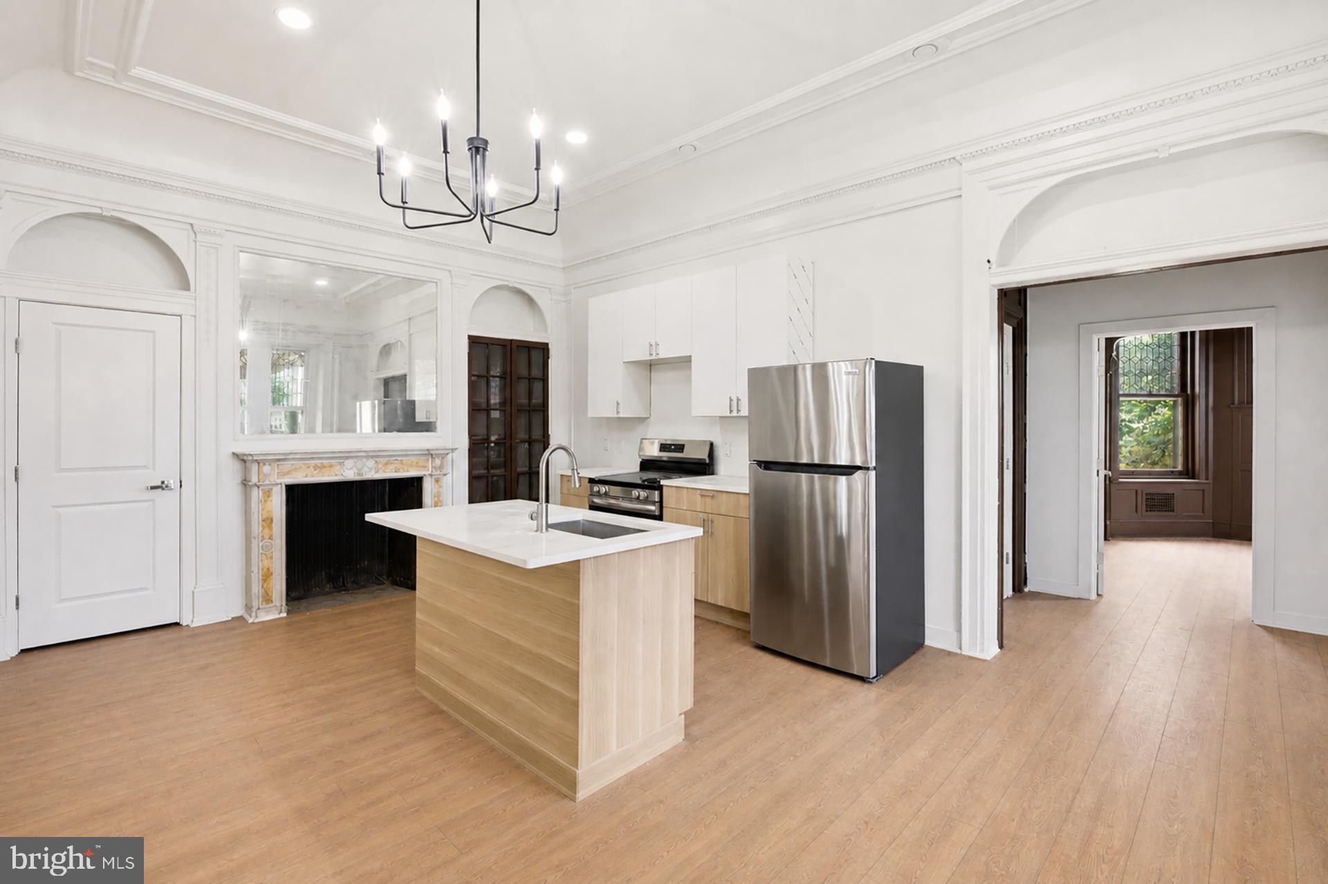6012 Ridge Avenue, Unit 1 Philadelphia, PA 19128 - Photo 3 of 17 a view of a kitchen with a sink a refrigerator and a fireplace