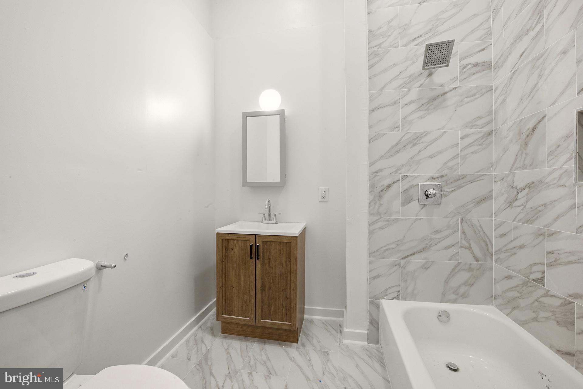 6012 Ridge Avenue, Unit 1 Philadelphia, PA 19128 - Photo 10 of 17 a bathroom with a sink a toilet and shower