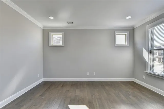 an empty room with windows fireplace and a ceiling fan