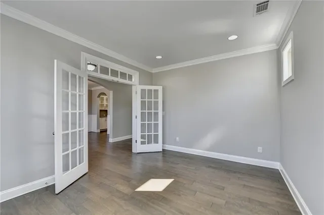 an empty room with wooden floor fireplace and windows