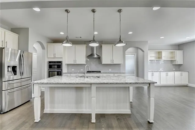 a kitchen with granite countertop white cabinets and white appliances