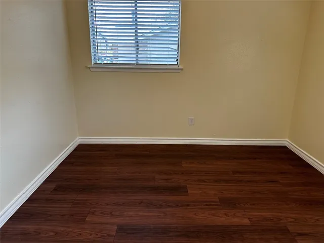 a view of a room that has wooden floor and a window