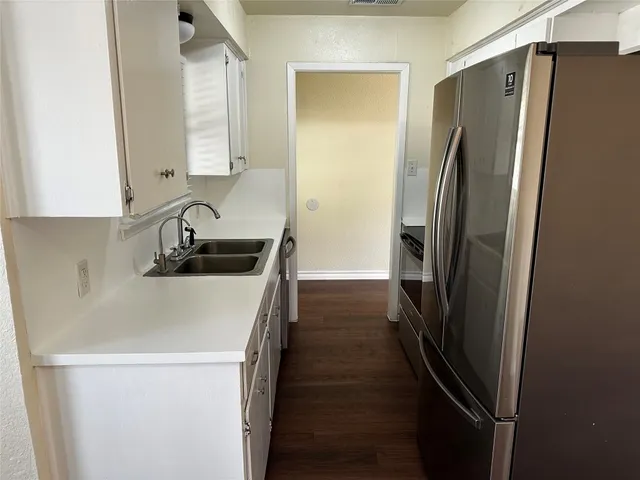 a kitchen with a refrigerator and a sink