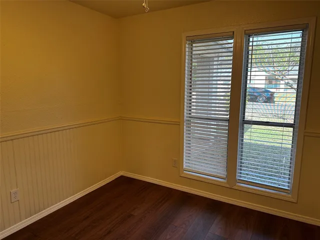 a view of a small space with wooden floor and a window