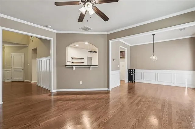 a view of a livingroom with wooden floor and a ceiling fan