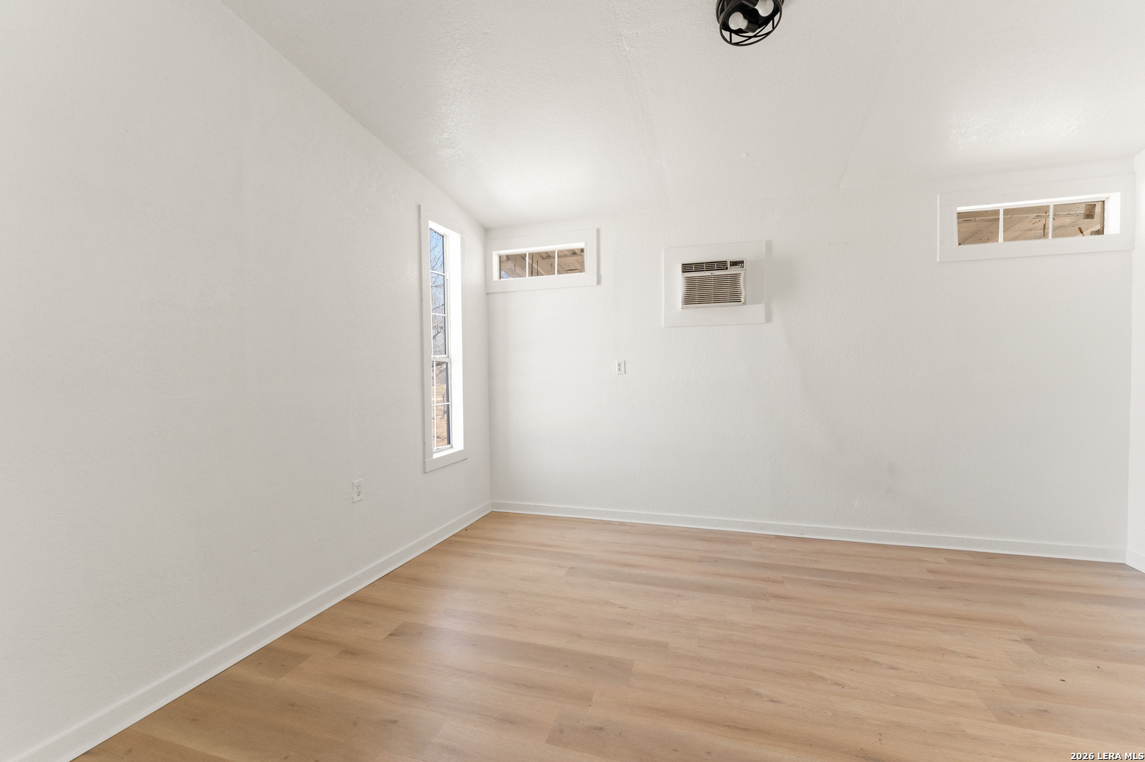 670 Quail Run Lytle, TX 78052 - Photo 27 of 31 an empty room with wooden floor and windows