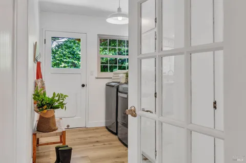 a utility room with stainless steel appliances a stove a window and a potted plant