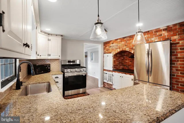 a kitchen with granite countertop a stove and a sink