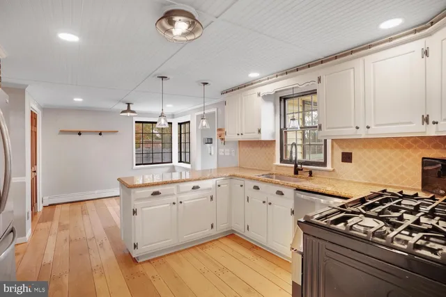 a kitchen with stainless steel appliances granite countertop a refrigerator and a stove top oven